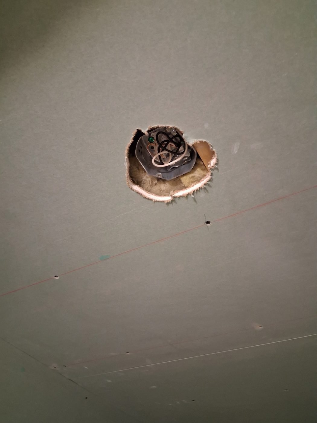 A ceiling opening cut around an electrical junction box