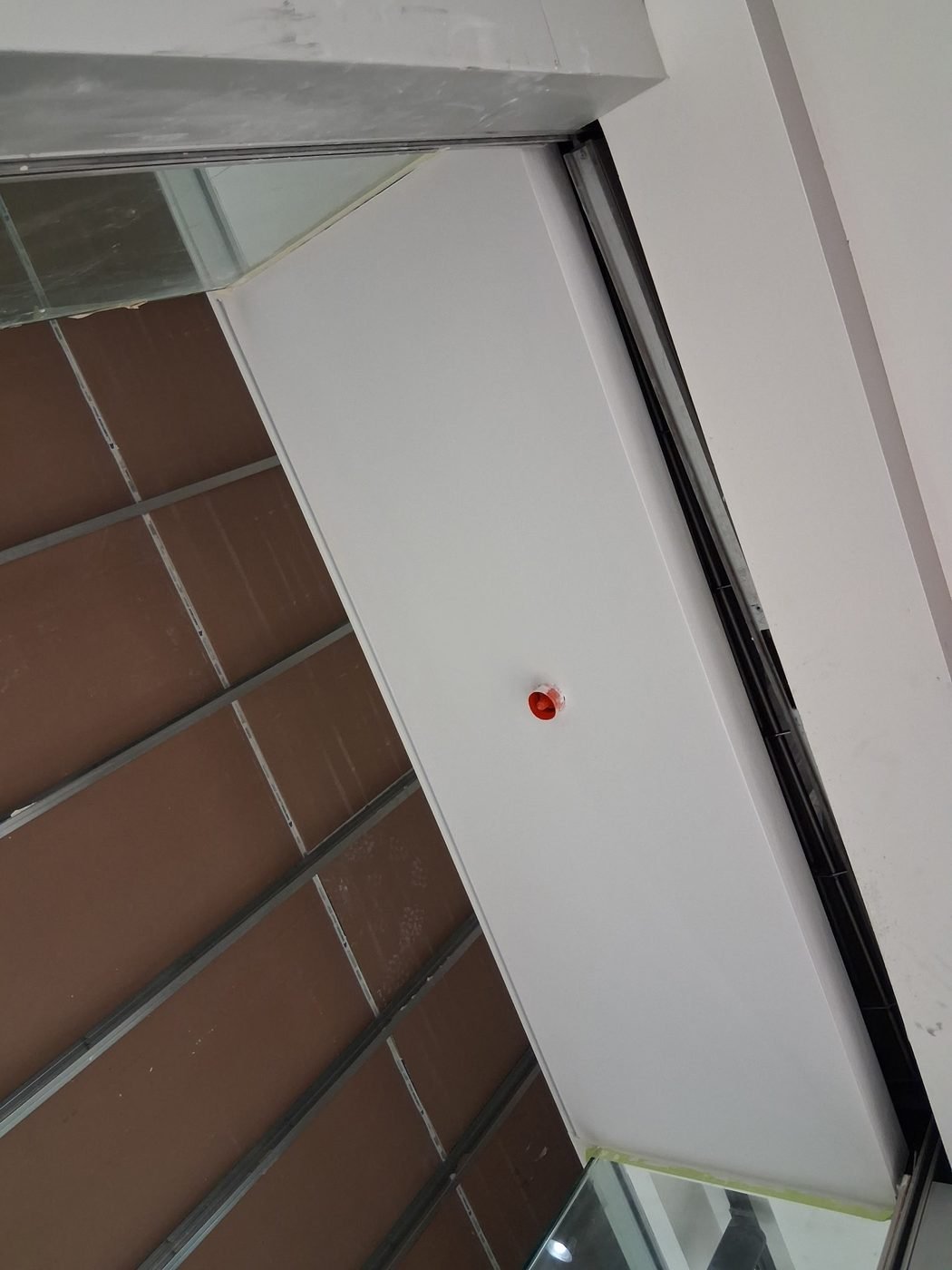 Commercial bulkhead detail finished against a suspended ceiling grid