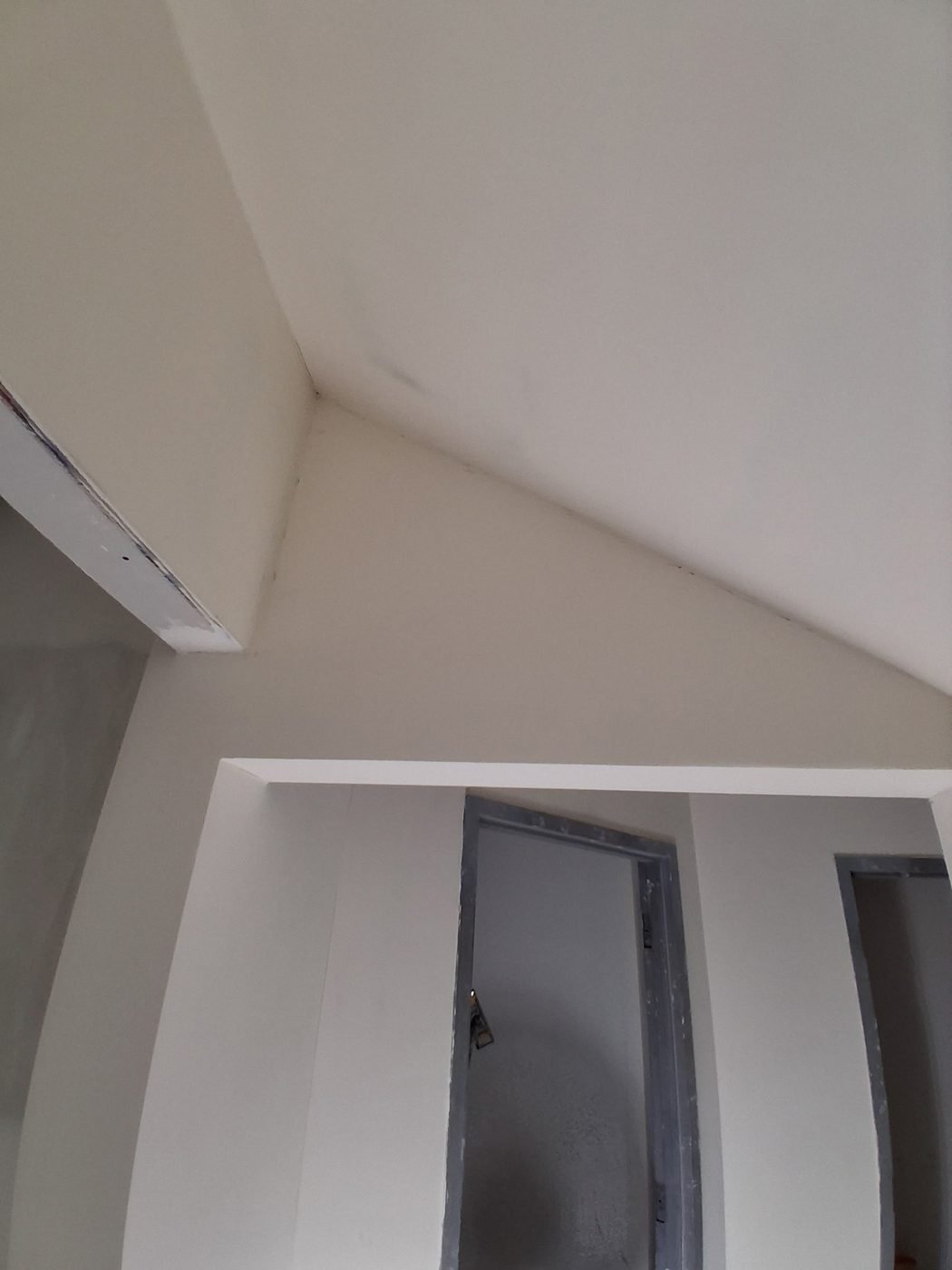 A finished and painted vaulted ceiling above framed door openings