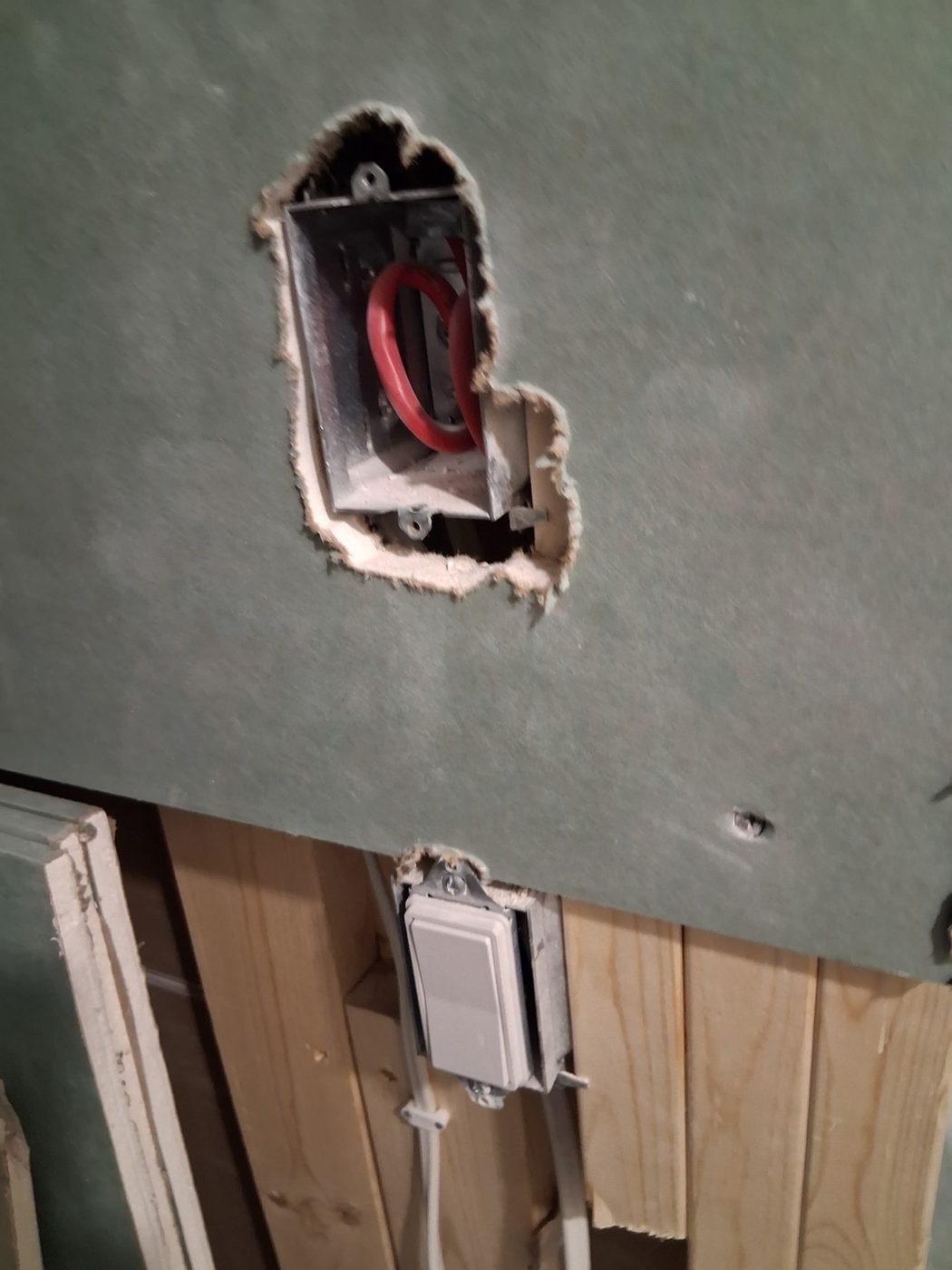 Moisture-resistant green drywall cut around an electrical box