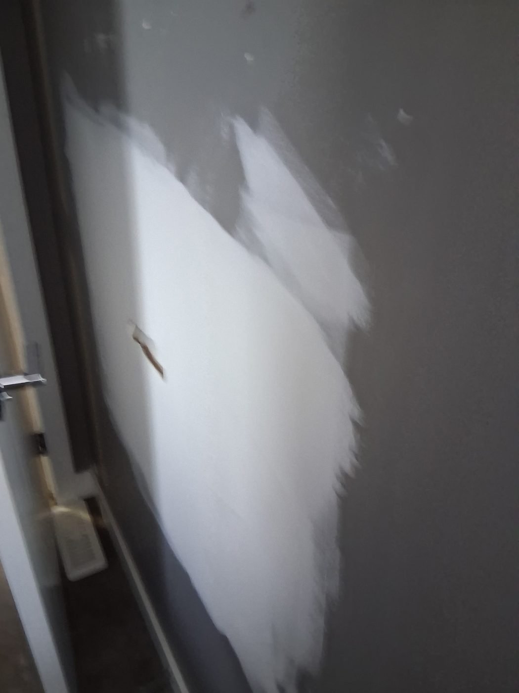 Skim coat of compound floated over a wall repair