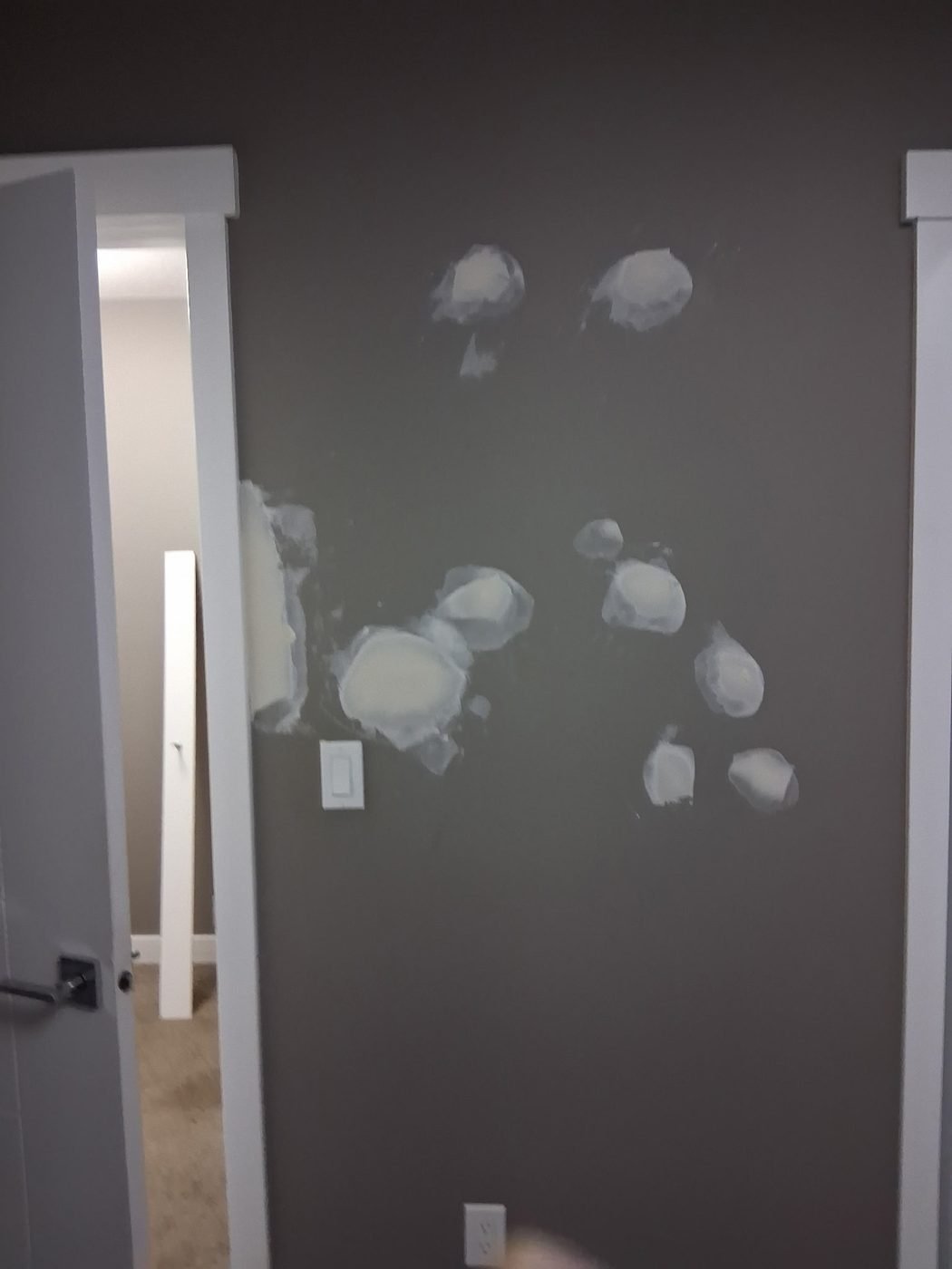 A hallway wall covered in filler patches ready for sanding