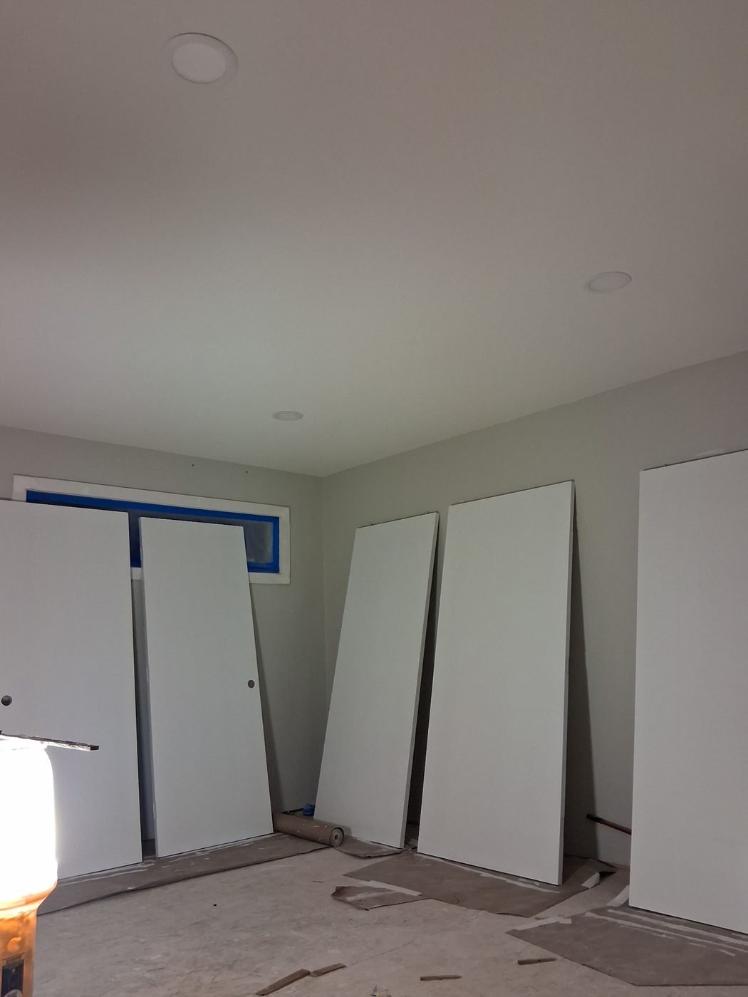Primed bedroom with pot lights and a masked window
