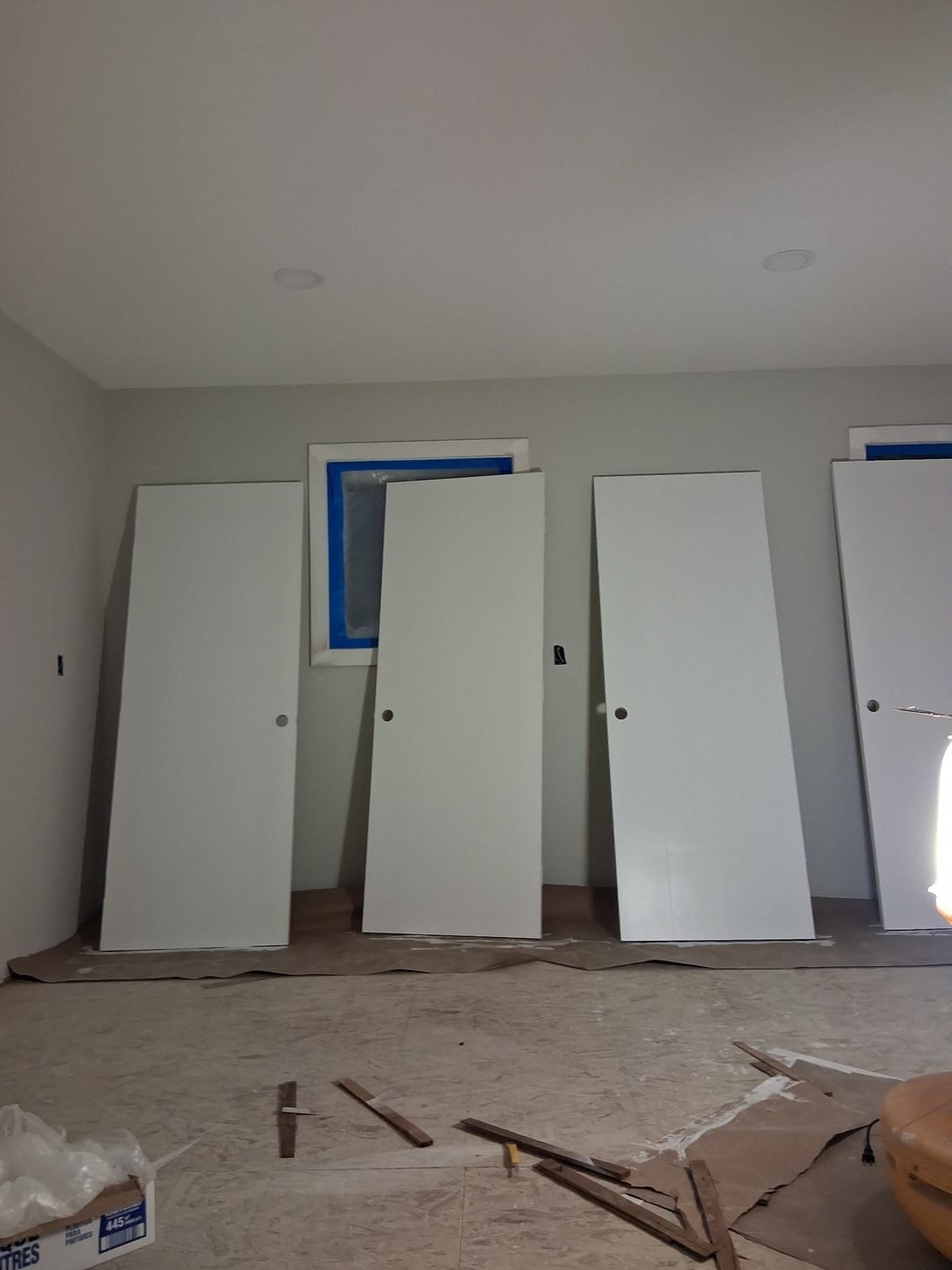 Primed room with interior doors leaning against the wall ready for installation