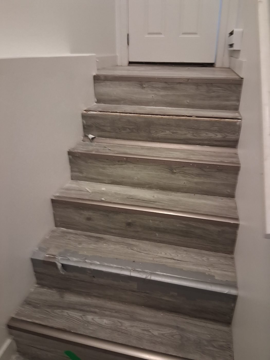 Staircase finished with grey vinyl plank treads and risers
