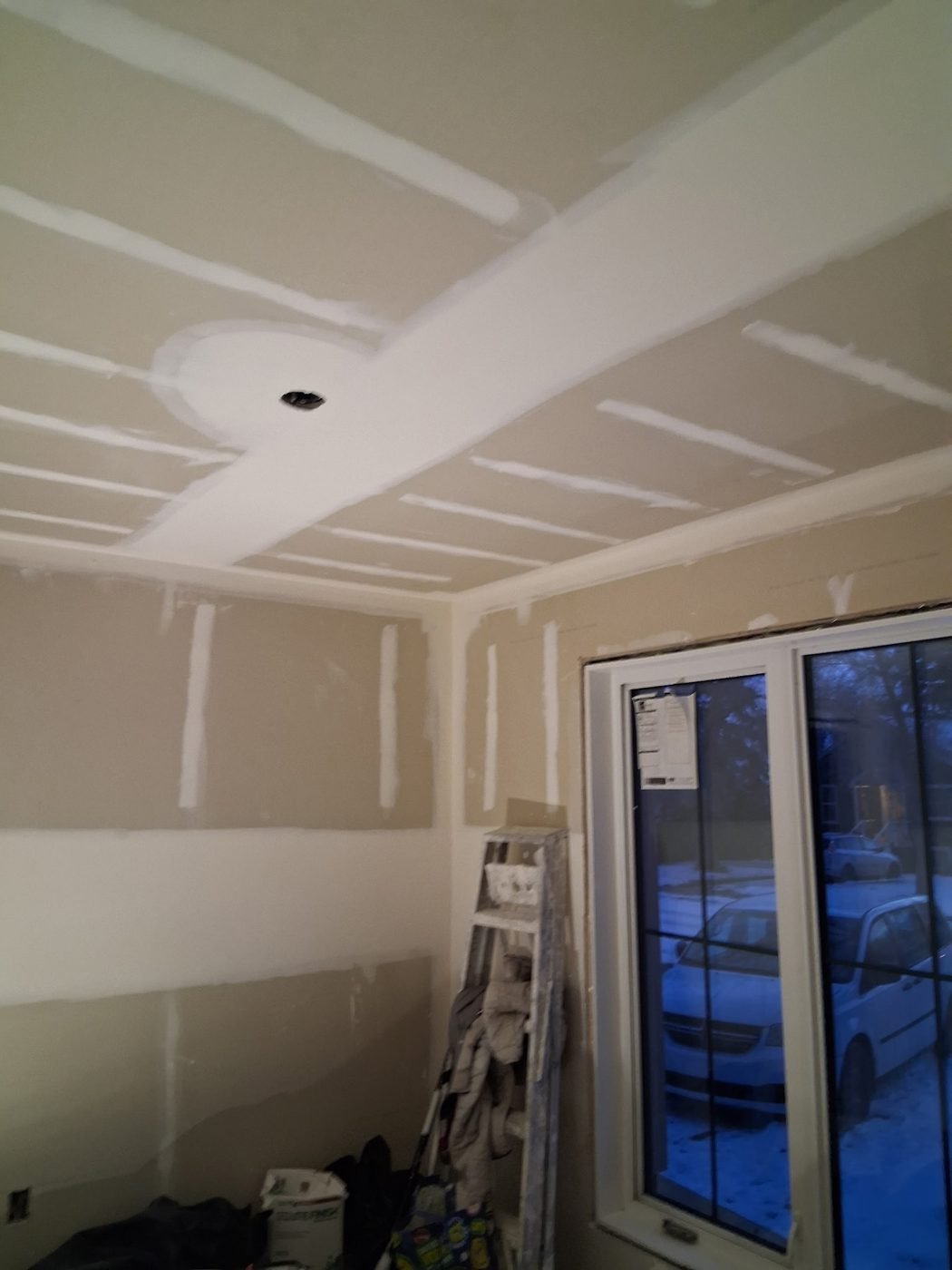 Taped room beside a patio door with snow visible outside