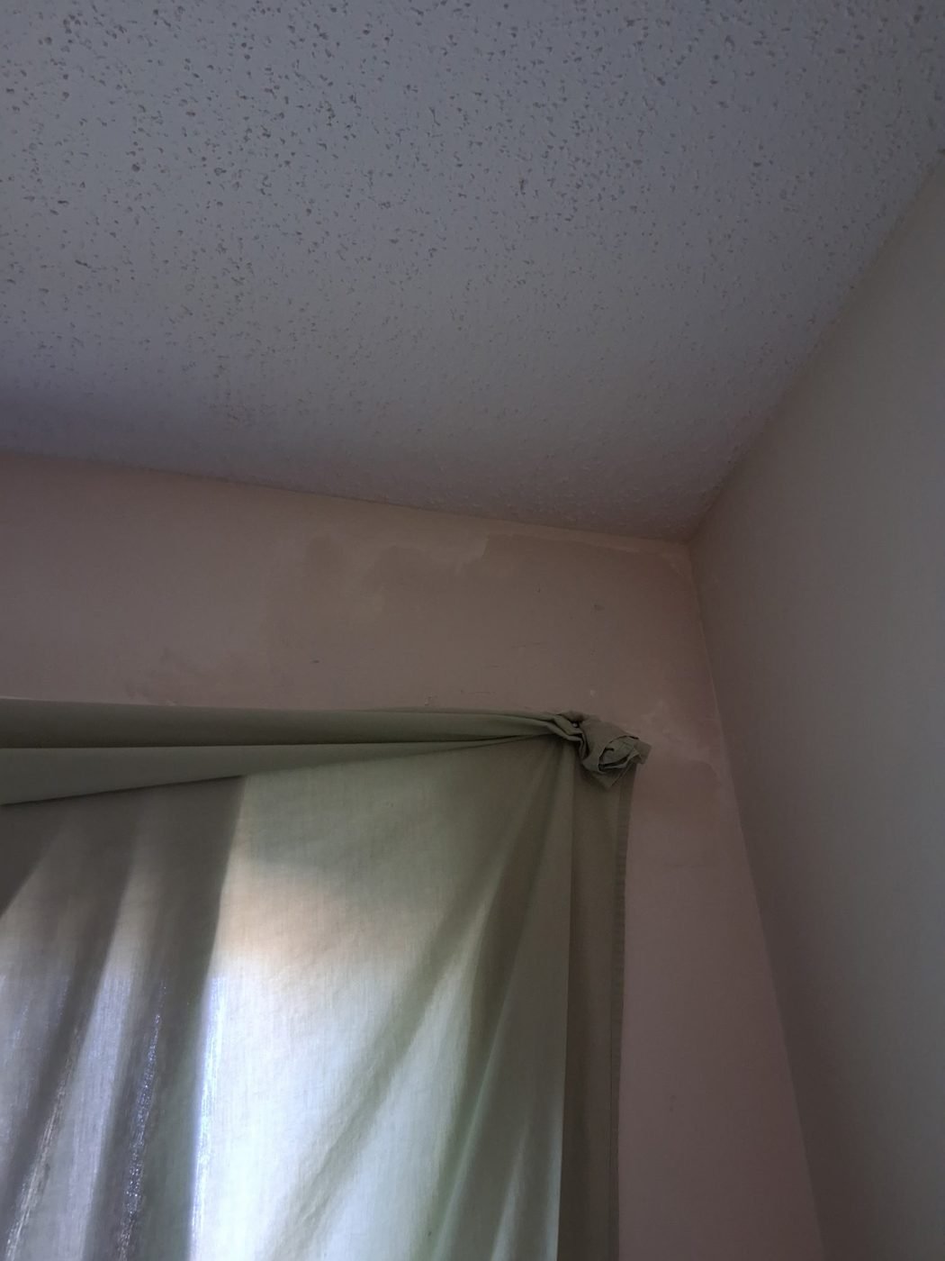 Clean finished wall corner beside a curtain